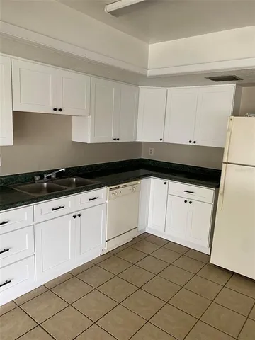 a kitchen with white cabinets and white appliances
