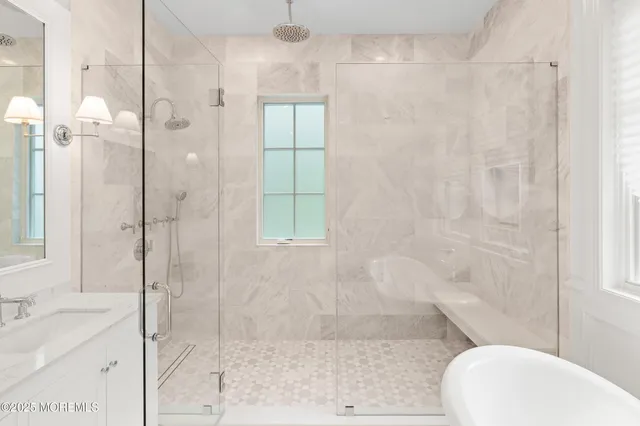 a bathroom with a granite countertop sink a mirror and shower
