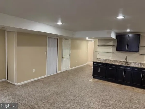 an empty room with wooden floor chandelier and entryway