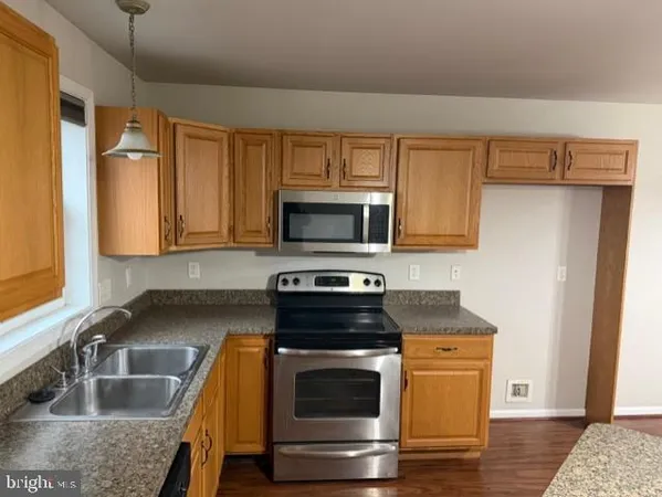 a kitchen with granite countertop a stove and a sink