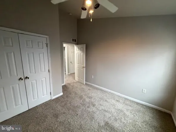 an empty room with wooden floor and a hallway