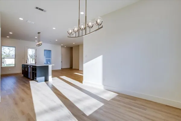 a view of a kitchen and dining table with a chandelier