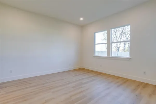a view of an empty room with wooden floor