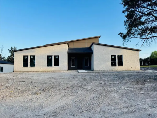 a view of a house with a backyard and road