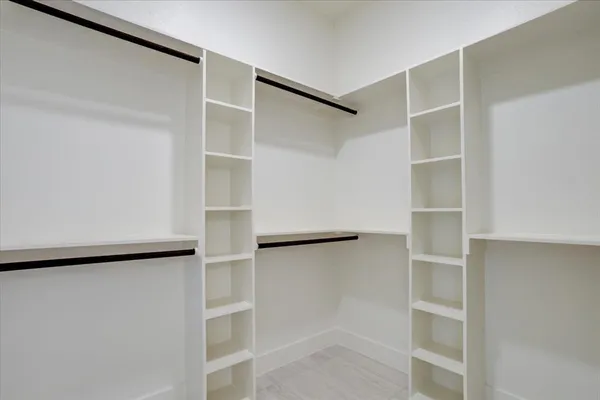 a view of walk in closet with empty racks
