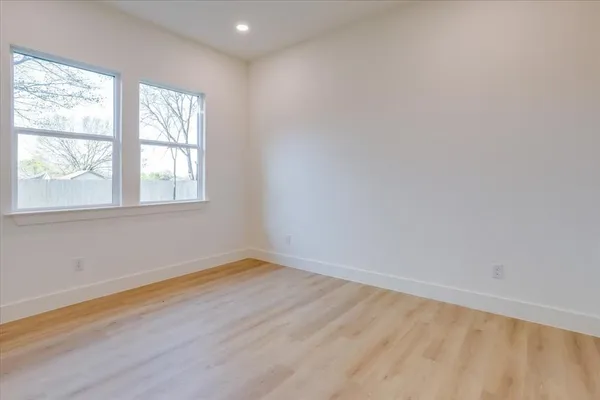 a view of an empty room with closet and a window