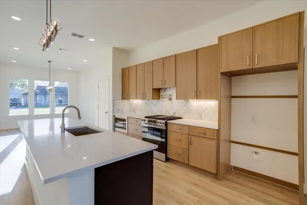 a kitchen with stainless steel appliances granite countertop a sink stove and refrigerator