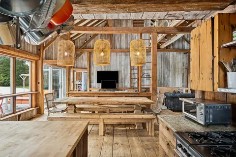 a kitchen with stainless steel appliances granite countertop a stove and a view of living room