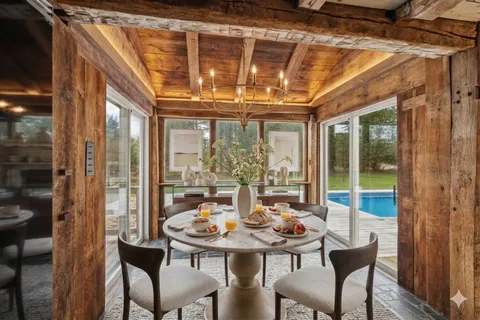 a view of a dining room with furniture a chandelier and wooden floor