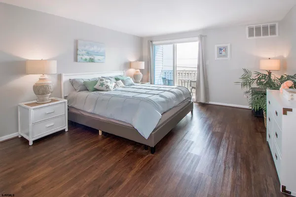 a bedroom with a bed and a wooden floor