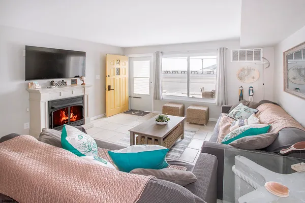 a living room with furniture a flat screen tv and a fireplace
