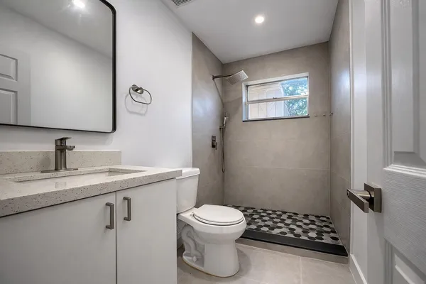 a bathroom with a granite countertop sink toilet and shower
