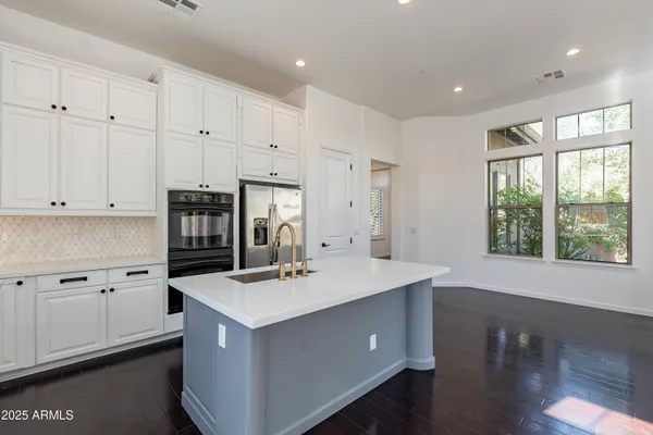 a kitchen with a sink a kitchen island and stainless steel appliances