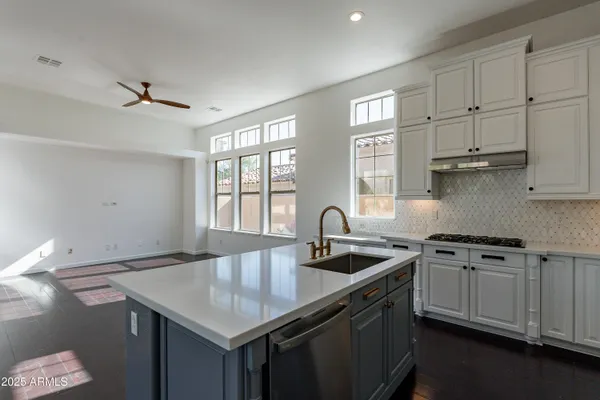 an empty room with wooden floor and ceiling fan