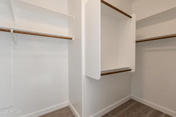 a view of a room with wooden floor and a ceiling fan