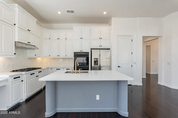 a kitchen with a sink dishwasher a dining table and chairs with wooden floor