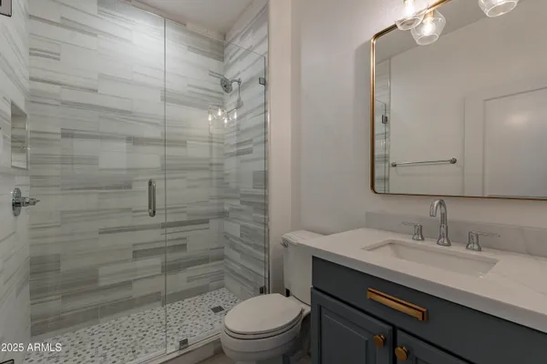 an empty room with wooden floor cabinet and windows