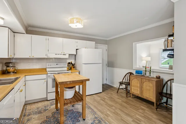 a room with a table chairs and a refrigerator