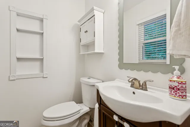 a bathroom with a sink a toilet and a mirror