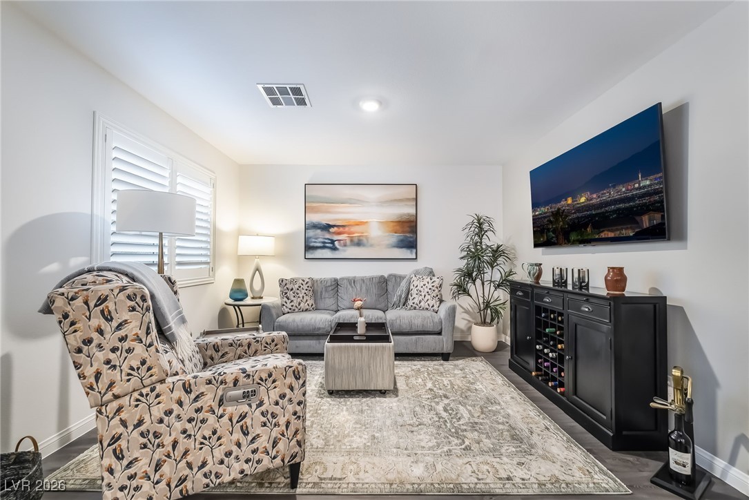 Living area with baseboards and dark wood-type flooring