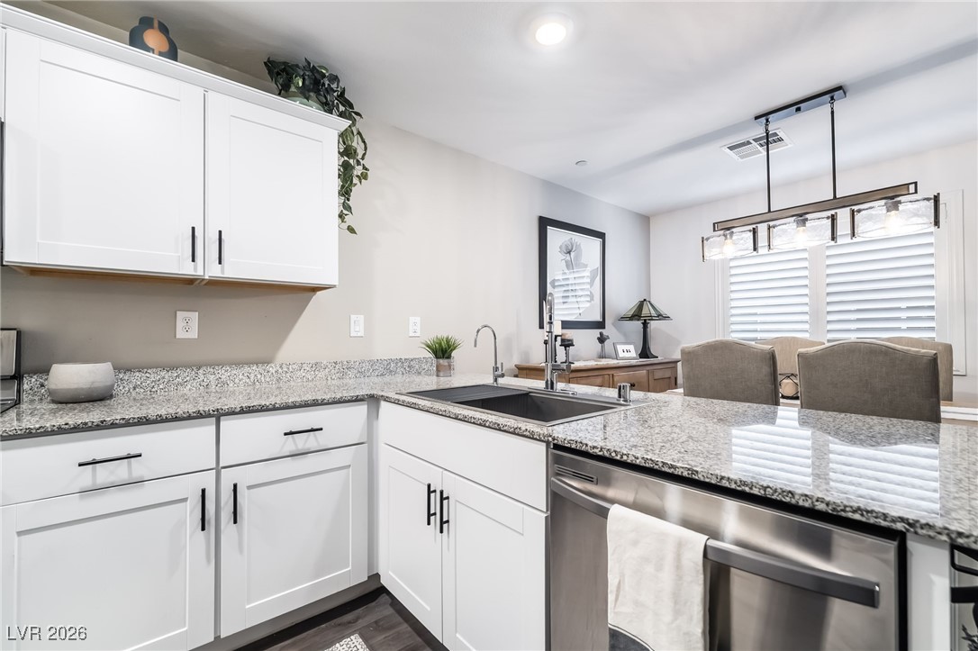 12235 Glass Desert Road, Unit 2 Las Vegas, NV 89183 - Photo 3 of 33 Kitchen featuring dishwasher, white cabinetry, and light stone countertops