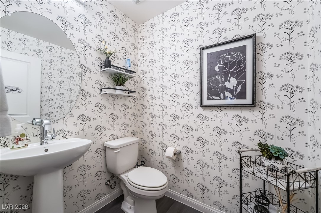 12235 Glass Desert Road, Unit 2 Las Vegas, NV 89183 - Photo 10 of 33 Half bathroom featuring toilet and wallpapered walls