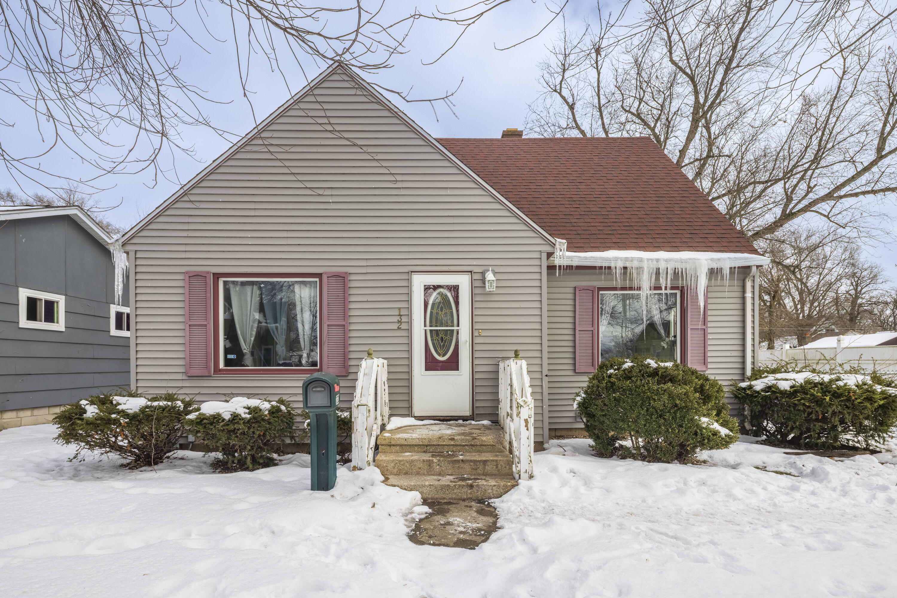 a front view of a house with a yard and potted plants