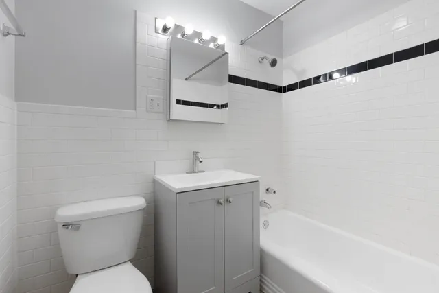 a bathroom with a sink a toilet a mirror and shower
