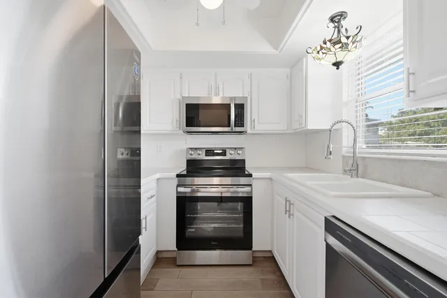 a kitchen with stainless steel appliances a refrigerator and a stove top oven