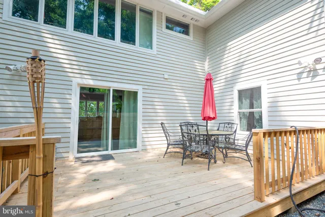 a patio with table and chairs and potted plants