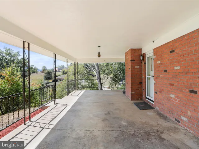 a backyard of a house with table and chairs under an umbrella