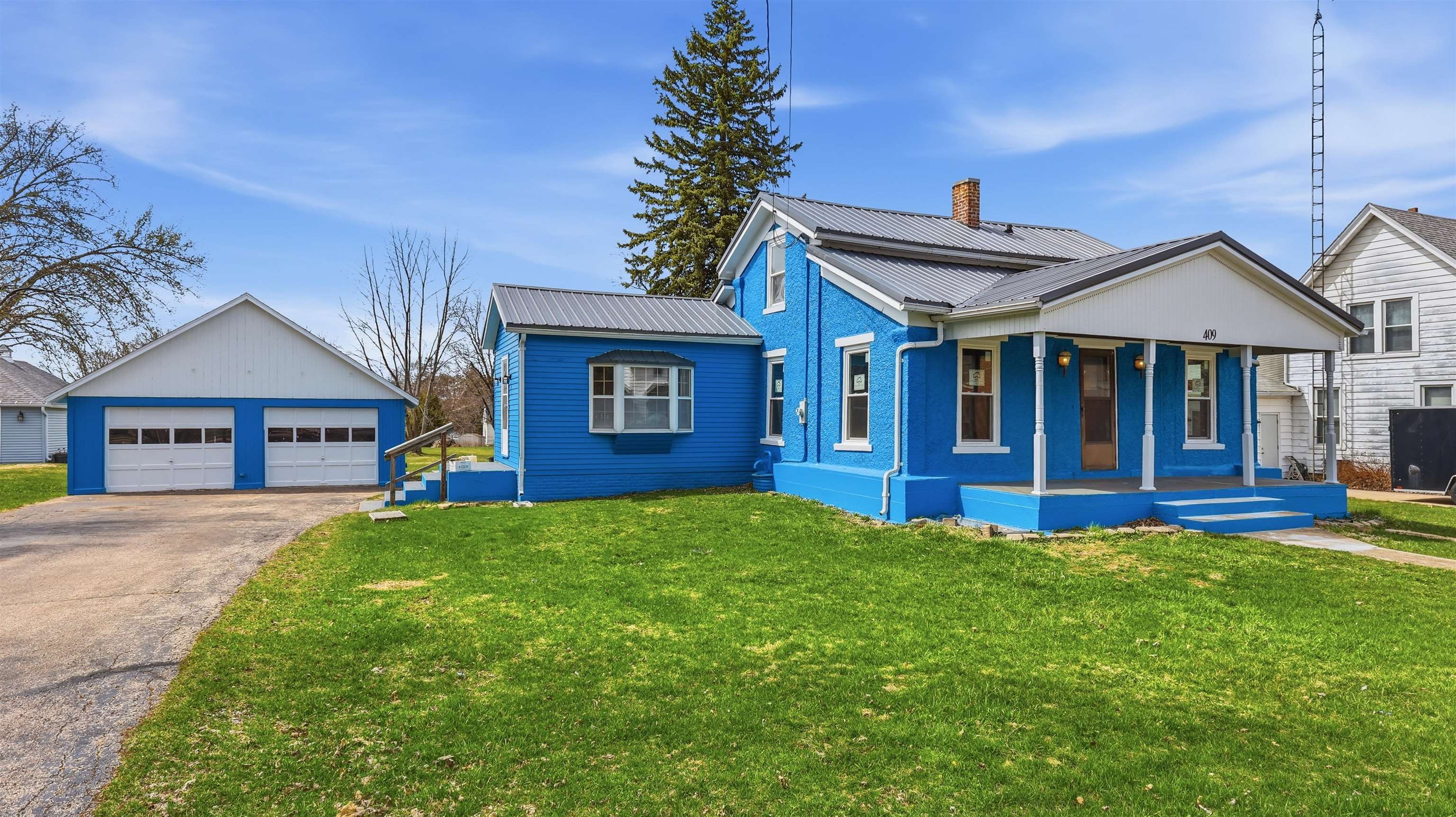 a view of a house with table and chairs in a yard