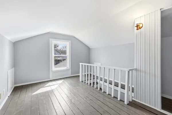 a view of a hallway with wooden floor and staircase