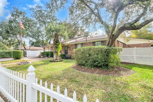 a view of a house with a yard and a large tree