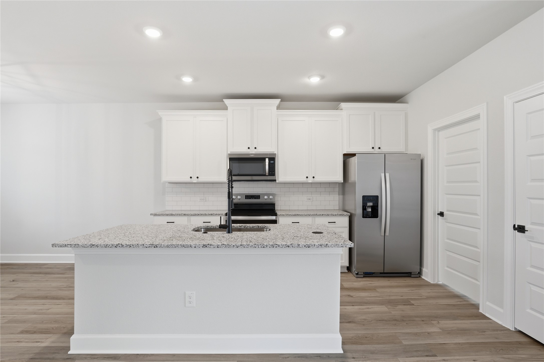 9320 Gladsome Path Manor, TX 78653 - Photo 22 of 34 a kitchen with stainless steel appliances a refrigerator stove microwave and cabinets