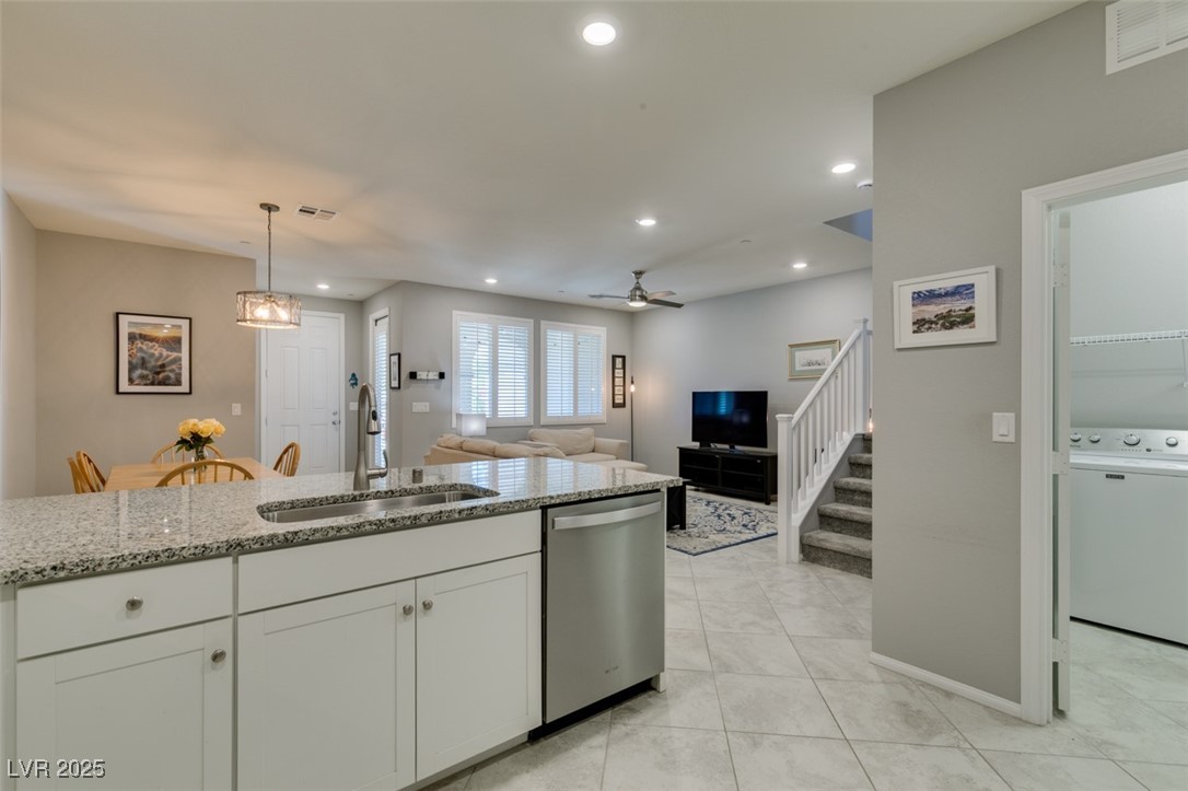 2870 Turnstone Ridge Street Henderson, NV 89044 - Photo 26 of 50 Kitchen featuring dishwasher, a sink, light stone countertops, recessed lighting, and white cabinets