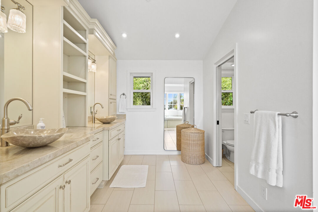 30081 Harvester Road Malibu, CA 90265 - Photo 13 of 33 a spacious bathroom with a double vanity sink and a mirror