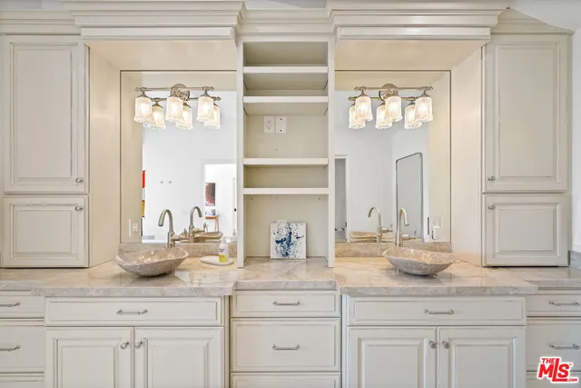 a bathroom with cabinets and mirror