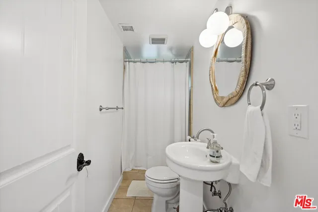 a bathroom with a sink a toilet and a mirror