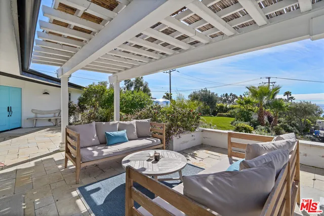 a view of a patio with table and chairs under an umbrella