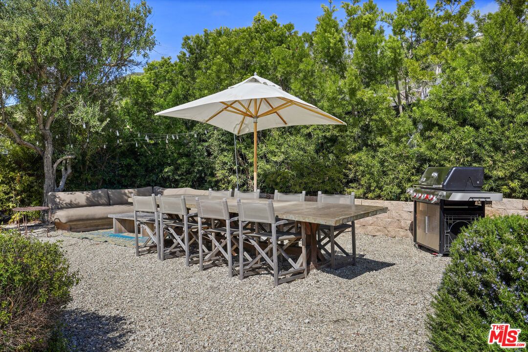 30081 Harvester Road Malibu, CA 90265 - Photo 30 of 33 a view of a patio with table and chairs under an umbrella