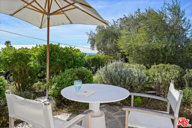 a view of a patio with a table chairs and a backyard
