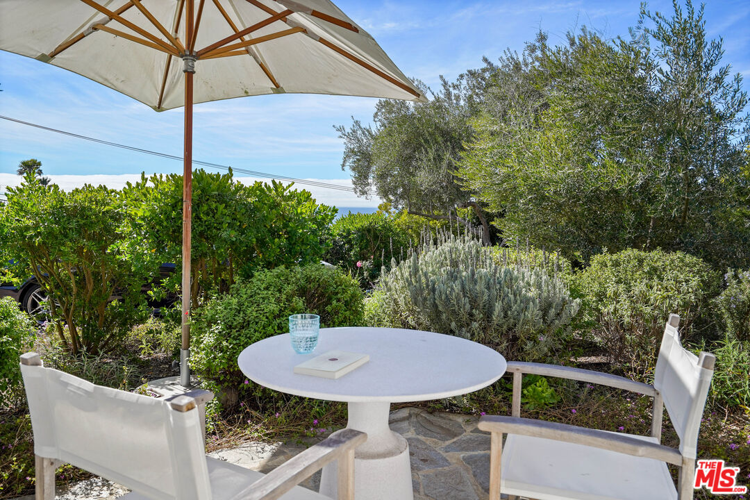 30081 Harvester Road Malibu, CA 90265 - Photo 32 of 33 a view of a balcony with a table and chairs under an umbrella