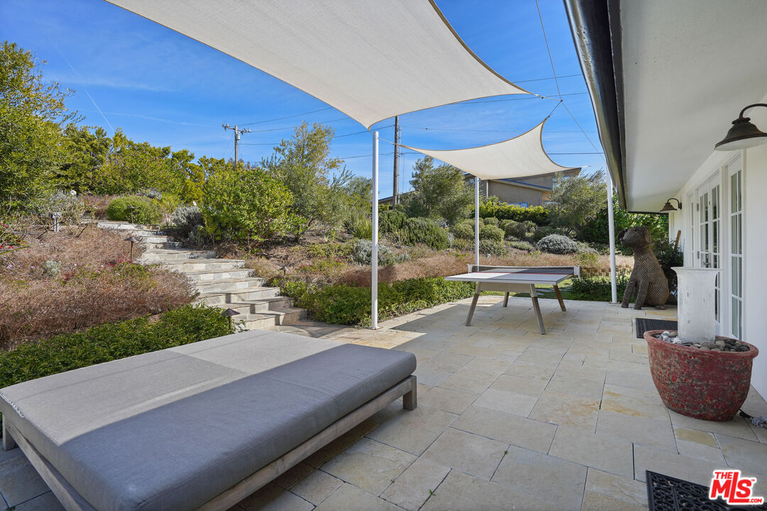 30081 Harvester Road Malibu, CA 90265 - Photo 33 of 33 a view of a patio with a table chairs and a backyard