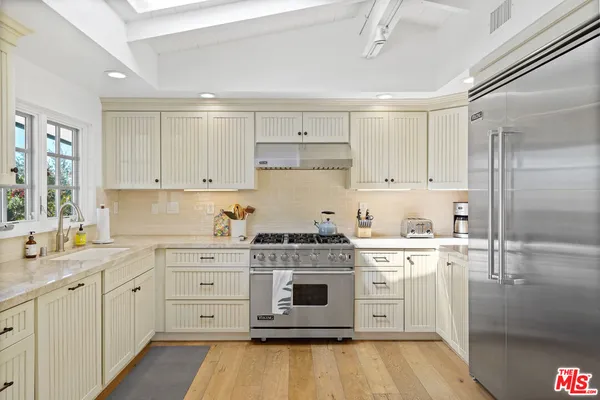 a white kitchen with a stove top oven