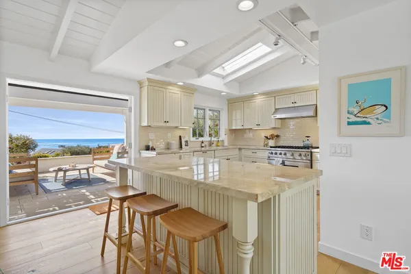 a kitchen with stainless steel appliances granite countertop a stove a sink dishwasher and a refrigerator with wooden floor