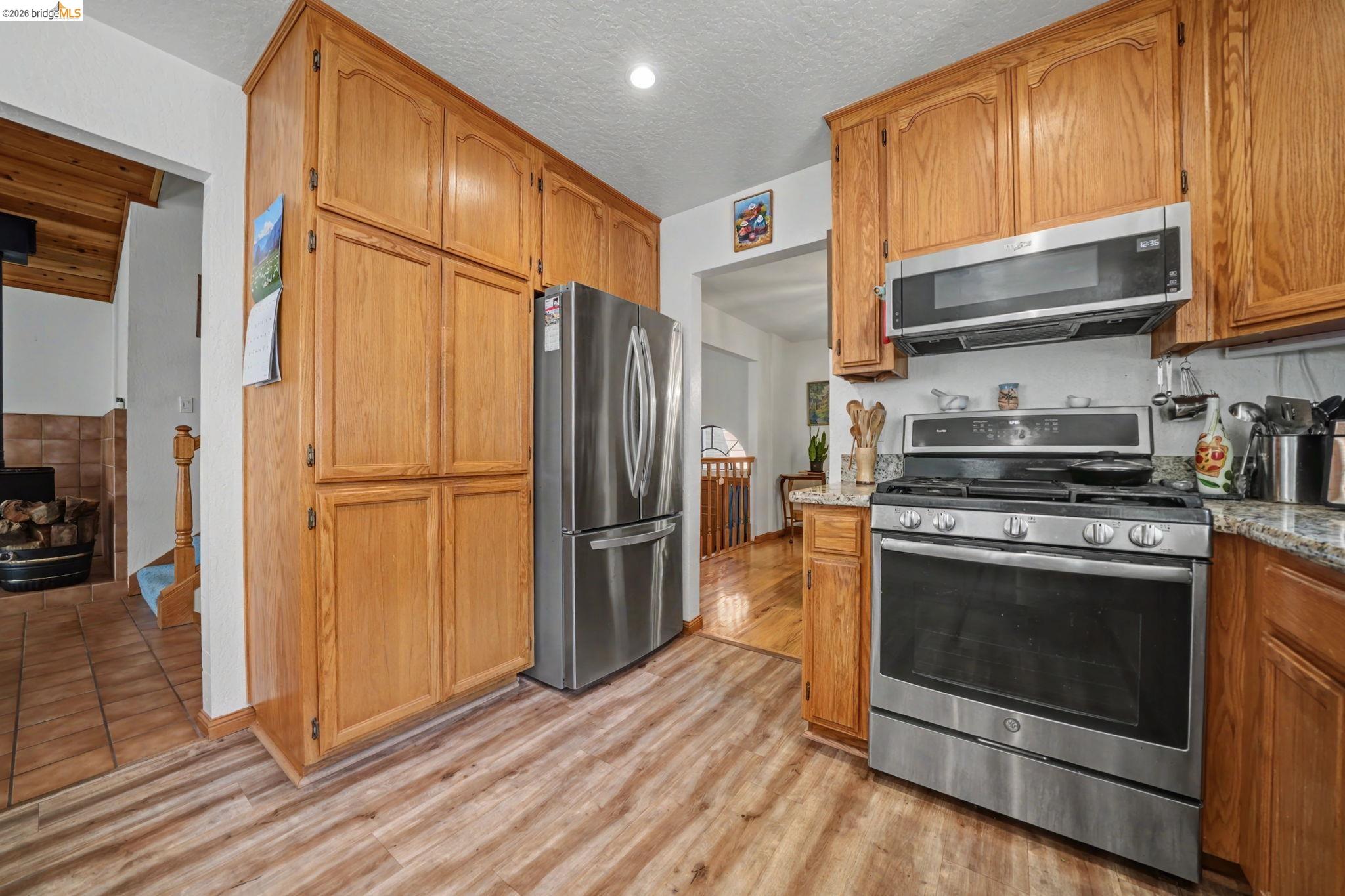 1554 Vine Maple Drive Murphys, CA 95247 - Photo 16 of 54 a kitchen with granite countertop a refrigerator stove and microwave