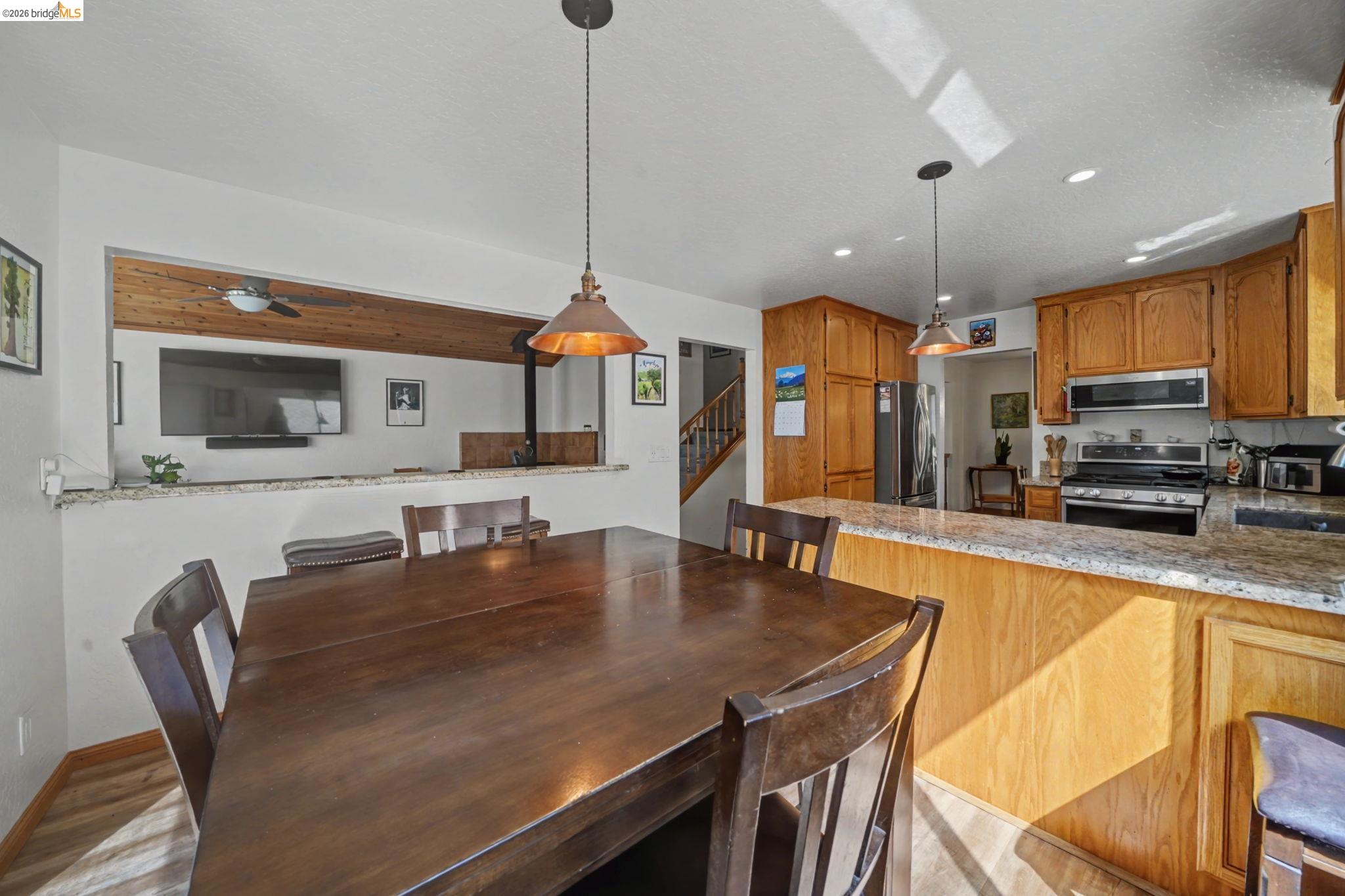 1554 Vine Maple Drive Murphys, CA 95247 - Photo 19 of 54 a kitchen with stainless steel appliances granite countertop a sink a stove a dining table chairs and view living room