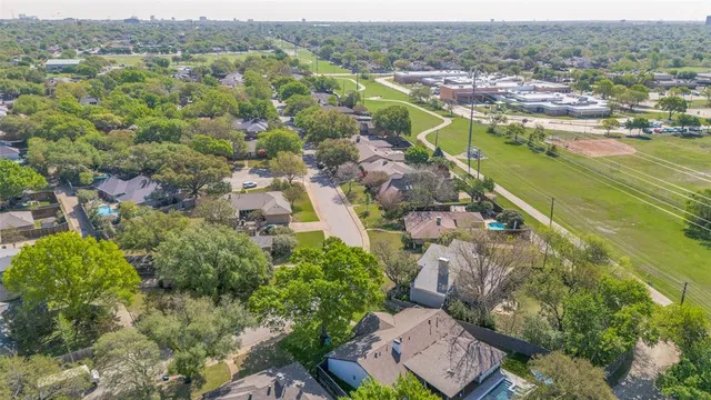an aerial view of a house with a yard and large trees