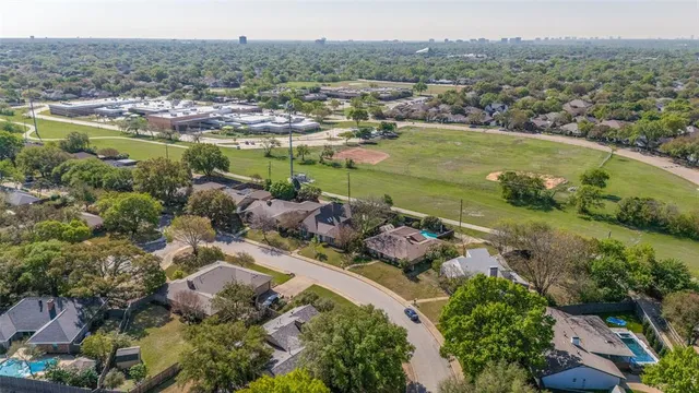 an aerial view of residential houses with outdoor space and trees